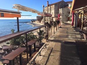an empty sidewalk next to the ocean with benches at Seafront Apartment Jadri in Umag +14 photos