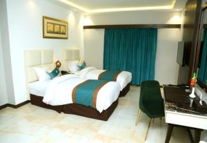 a hotel room with a large bed and a desk at Best Western Plus Multan in Multan +38 photos