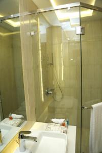 a bathroom with a sink and a shower with a mirror at Faletti's Grand Hotel Multan in Multan