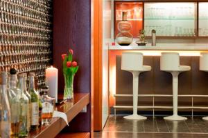 un bar con taburetes blancos y botellas de vino en Hotel & Restaurant Rosenthal Casino en Selb