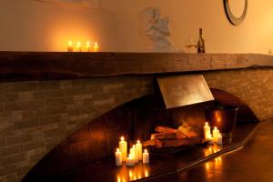 a fireplace with candles and a statue of a woman at Hotel & Restaurant Rosenthal Casino in Selb