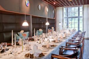 una mesa larga en una habitación con sillas y vasos en Hotel & Restaurant Rosenthal Casino en Selb