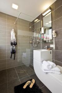 uma casa de banho com um lavatório e um chuveiro com um espelho. em Hotel & Restaurant Rosenthal Casino em Selb