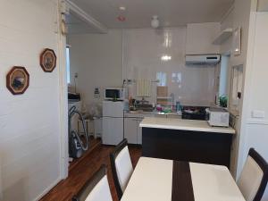 a small kitchen with a table and chairs in it at Maribu Beach House in Yamada