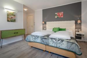 una camera da letto con un grande letto con accenti verdi di Hotel Aster a Merano