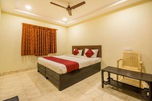 a bedroom with a bed and a table and a window at Hotel Siri Grand in Visakhapatnam +6 photos