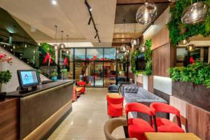 a restaurant with red chairs and a bar at Hotel Aria in Užice