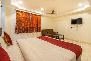 a hotel room with a bed and a tv at Hotel Siri Grand in Visakhapatnam