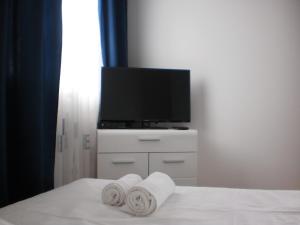 a bedroom with a tv and towels on a bed at Apartment Dalmatino in Split