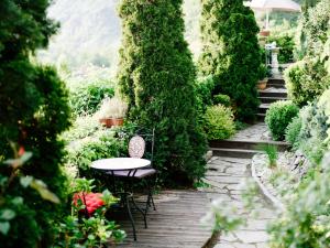 a patio with a table and chairs in a garden at Hotel Schloss D&uuml;rnstein in D&uuml;rnstein
