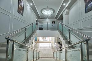 spiralne schody w budynku z żyrandolem w obiekcie BAL Tabassum Hotel w mieście Toshloq