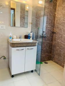 a bathroom with a sink and a shower at The Karma Square near India Expo Mart in Noida