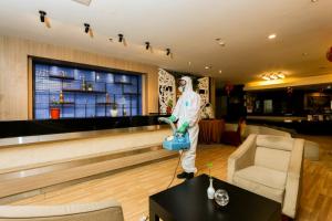 a man standing in a bar in a room at Serela Riau by KAGUM Hotels in Bandung