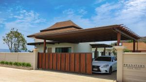 een huis met een auto ervoor geparkeerd bij Pranatarn Pool Villa Beach Night Cottage in Pran Buri