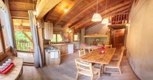 a kitchen and dining room with a wooden table in a cabin at Mas Antico Molino in Livo +17 photos