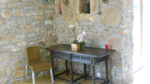 een stenen muur met een tafel en twee stoelen bij Casa Narzana in Villar