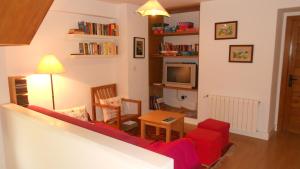 sala de estar con sofá rojo y TV en Casa Narzana, en Villar
