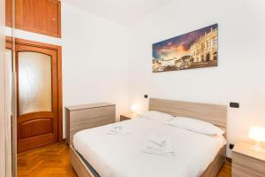 ein Schlafzimmer mit einem weißen Bett und einem Bild an der Wand in der Unterkunft Piazza Bengasi Cozy Apartment in Turin