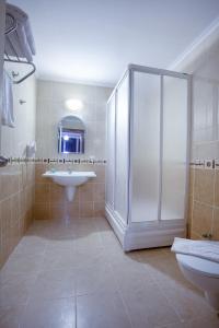 een badkamer met een douche, een wastafel en een toilet bij Kaila City Hotel in Alanya