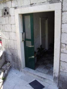 eine grüne Tür in einem Steingebäude mit einer Tür in der Unterkunft Studio Apartment Sretna in Split