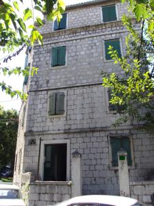 a stone building with green shutters on it at Studio Apartment Sretna in Split