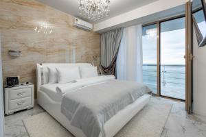 um quarto com uma cama branca e uma grande janela em Wellness СПА-Отель Грейс Горизонт em Sochi