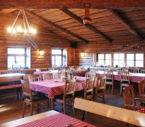 un comedor con mesas y sillas en un restaurante en Hotel am Interpark, en Großmehring