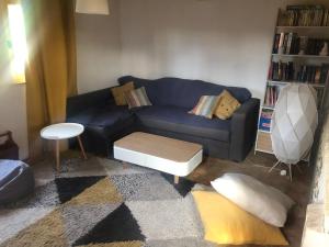 sala de estar con sofá azul y mesa en Le Hibou Perché, en Lieurey