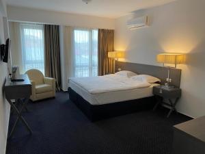 a hotel room with a bed and a chair at Urban 7 Residence in Bucharest