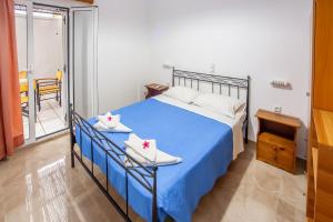 a bedroom with a blue bed and a balcony at Kavousanos Apartments in Istron +106 photos