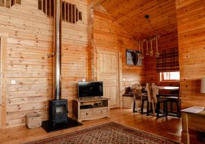 ein Wohnzimmer mit einem Holzofen in einer Hütte in der Unterkunft Pentland Lodge in Gorebridge