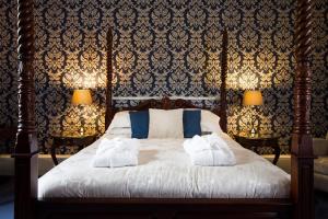 a bedroom with a bed with two towels on it at Elm Grove Country House in Tenby