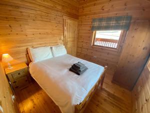 ein Schlafzimmer mit einem Bett in einer Holzhütte in der Unterkunft Pine Lodge in Gorebridge