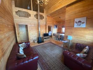 a living room with leather furniture in a cabin at Pine Lodge in Gorebridge
