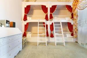 1 Schlafzimmer mit 2 Etagenbetten mit roten Vorhängen in der Unterkunft Villa I Giardini di Marzo in Guagnano