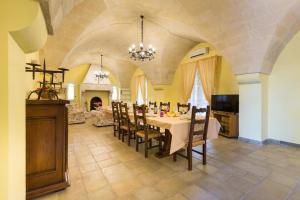 ein großes Esszimmer mit einem Tisch und Stühlen in der Unterkunft Villa I Giardini di Marzo in Guagnano