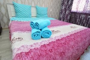 een bed met blauwe handdoeken erop bij Мода в доме 14 in Oral