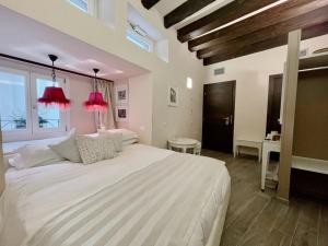 a bedroom with a large white bed with red lamps at B&B Verona Centro in Verona