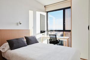 a hotel room with a bed, desk, and a window at Resa Patacona in Valencia