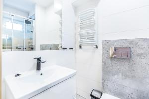 een witte badkamer met een wastafel en een douche bij OMORIKA - Wierch Rusiński in Bukowina Tatrzańska