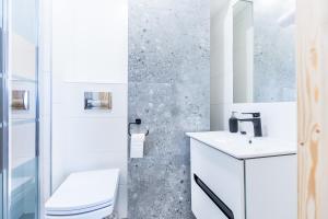 a bathroom with a white toilet and a sink at OMORIKA - Wierch Rusiński in Bukowina Tatrzańska