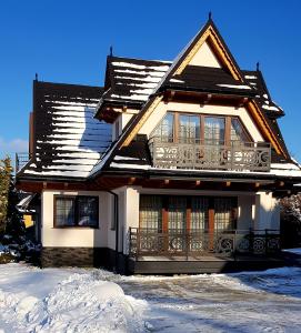 una casa con techo cubierto de nieve en Domki U Hani, en Murzasichle