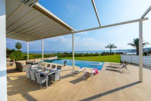 a patio with a table and chairs and a pool at Infinity Villa in Protaras