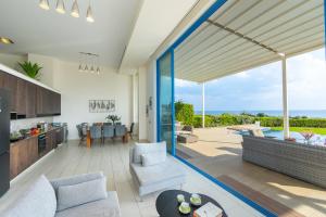 Una sala de estar abierta con vista al mar. en Infinity Villa, en Protaras
