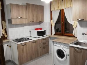 a kitchen with a microwave and a washing machine at Appartamento Sofia in Lazise