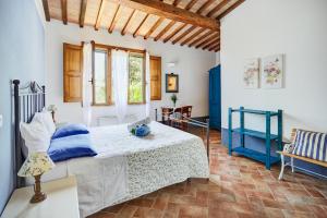 a bedroom with a bed with blue and white sheets at Agriturismo Lunadoro in Monticchiello