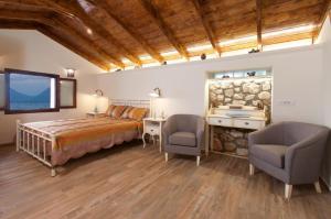 een slaapkamer met een bed en 2 stoelen en een televisie bij Endless Blue House in Sami