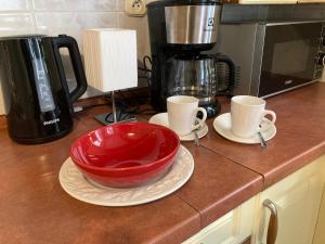 a kitchen counter with a red bowl and two cups at Apartament Centrum in Kołobrzeg