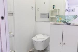 een witte badkamer met een toilet en een glazen kom bij Classy Two Bedroom View in Lissabon