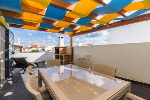 eine Terrasse mit einem Tisch und Stühlen auf dem Dach in der Unterkunft Golden Maré BY ALGARVEMANTA in Manta Rota